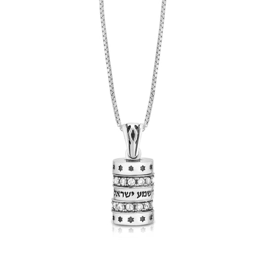 A sterling silver pendant designed as a small cylinder with a blessing and white cubic zirconia embellishments.