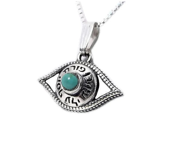 A silver pendant in the design of an eye, with the blessing "May the Lord open His good treasure" embedded with a turquoise stone.