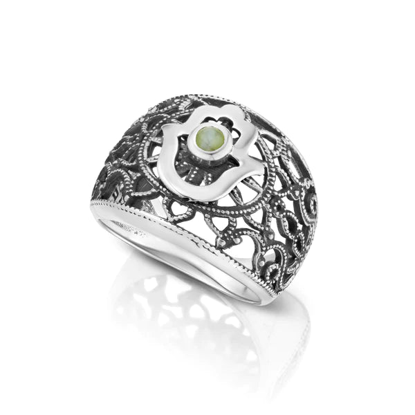 A silver signet ring adorned with a Hamsa symbol and a Cat's Eye stone.