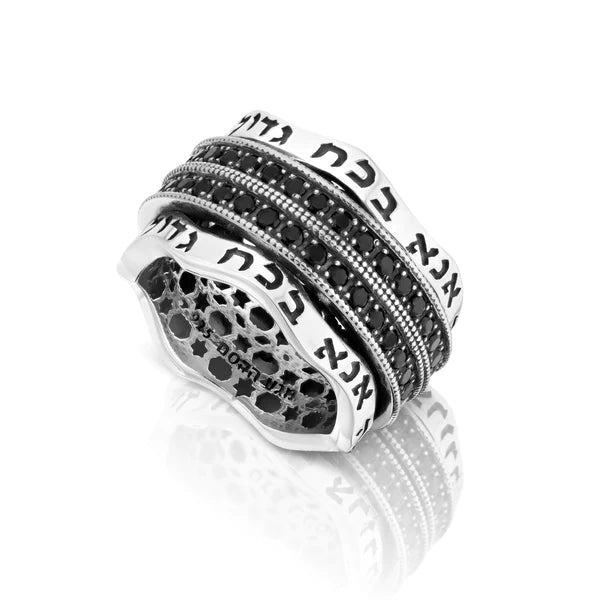 A rotating silver ring with the engraved phrase "Ani BeKoach" (Please with Strength) in a wavy design.