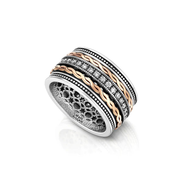 A spinning ring made of silver with red gold accents, adorned with cubic zirconia stones.