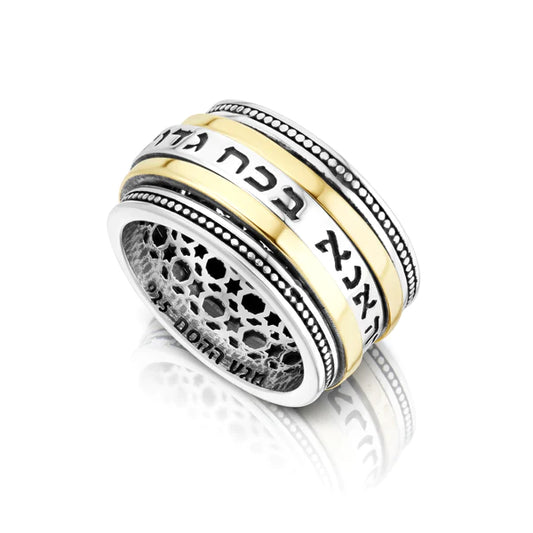 A silver ring with a combination of gold and the blessing "Ana B'koach" engraved on it.